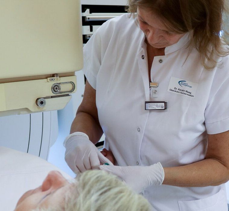 Frau spritzt Patientin Kontrastmittel